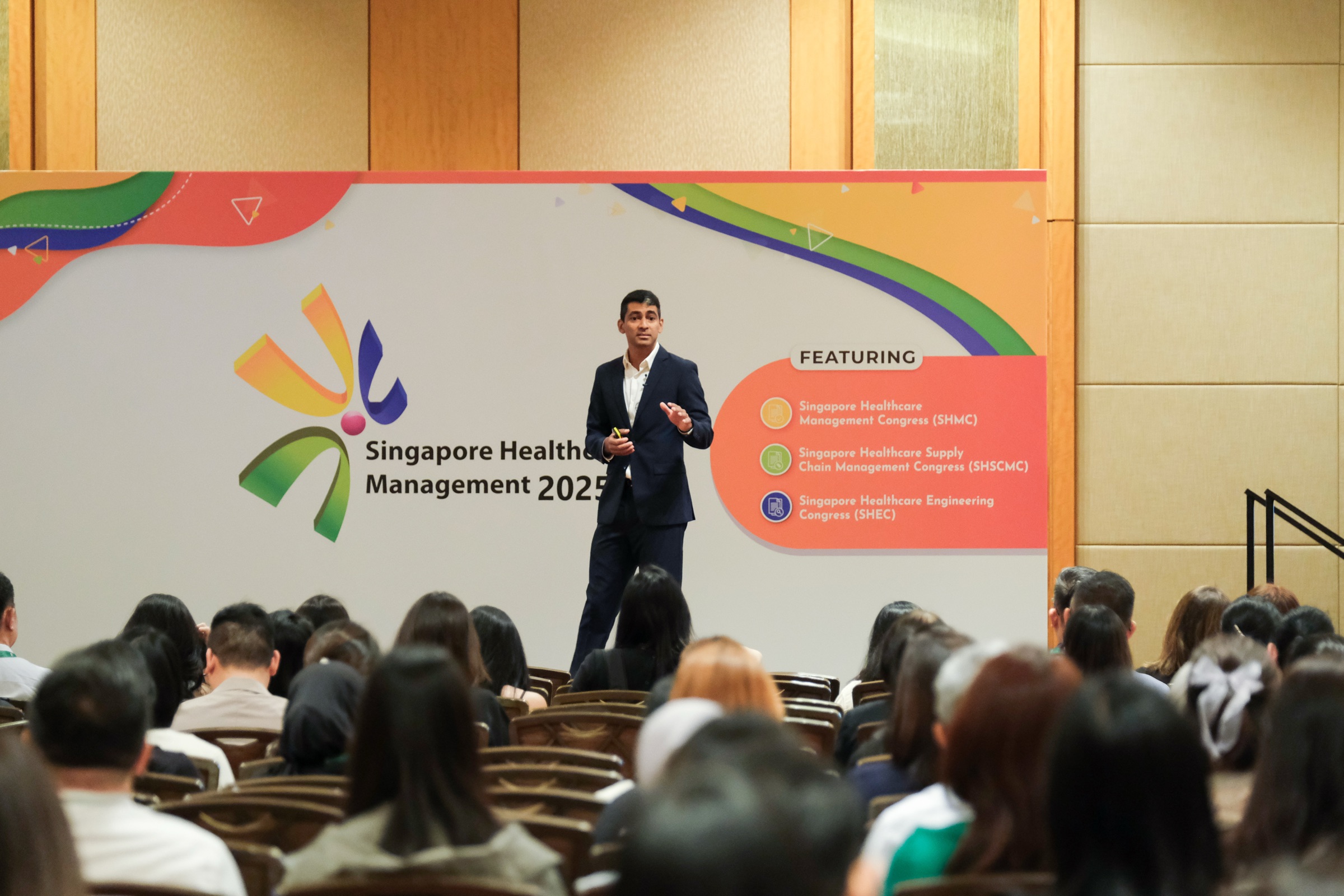 Gaurav Keerthi speaking on stage to a seated audience, Singapore Healthcare Management 2025.