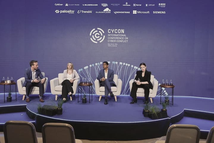 A four-person panel seated on a round stage beneath the CyCon conference backdrop.