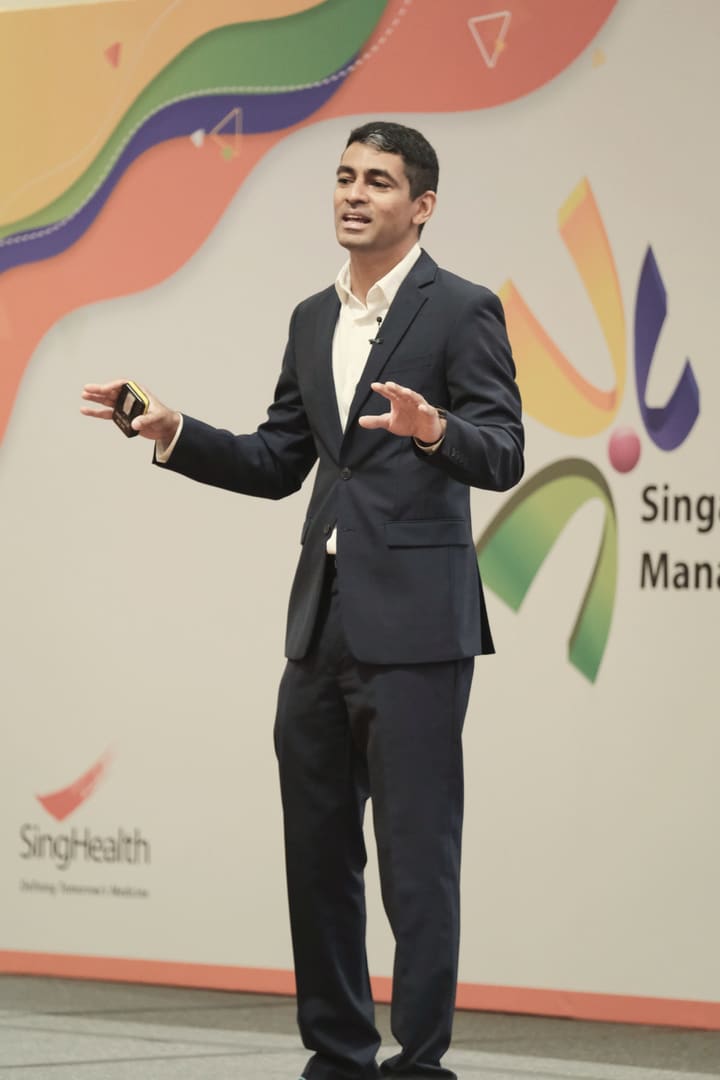 Gaurav on stage, gesturing to the audience as he speaks.